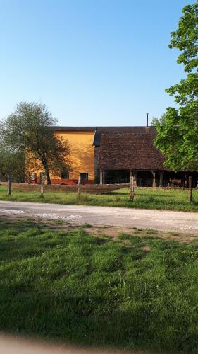 une maison avec une route à côté d'un champ d'herbe dans l'établissement la maison du potier proche de Guedelon, à Saint-Amand-en-Puisaye