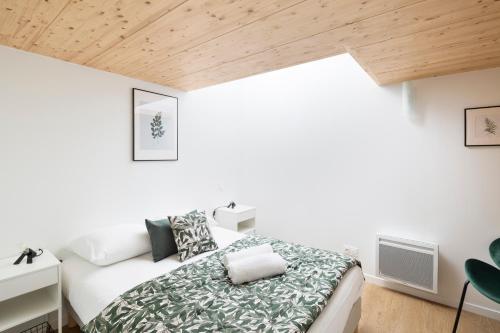 - une chambre avec un lit et un plafond en bois dans l'établissement LA DEROBEE - Havre de paix en ville, à Rennes