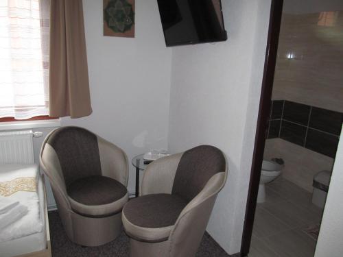 two chairs in a bathroom with a shower and a toilet at A+S Penzion Podzamok in Spišské Podhradie