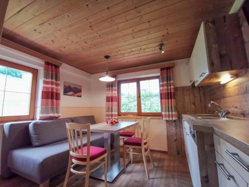 eine Küche und ein Wohnzimmer mit einem Tisch und Stühlen in der Unterkunft Ferienhof Haindlbauer in Kirchberg in Tirol