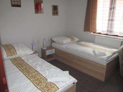 a room with two beds and a window at A+S Penzion Podzamok in Spišské Podhradie