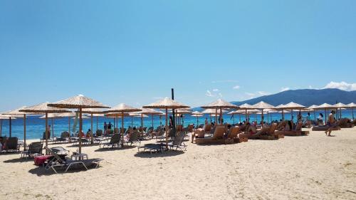 a group of people sitting on a beach with umbrellas at Apartment Marina 2 in Asprovalta