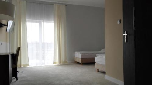 um quarto com uma cama e uma janela em Hotel Ostoja em Lipówki