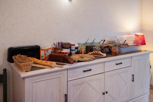 a counter top with food on top of it at LOGIS-Hôtel Restaurant Auberge Les Vallées Du Perche in Vichères