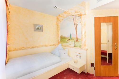 a small bedroom with a bed and a window at AKZENT Hotel Restaurant Altdorfer Hof in Weingarten