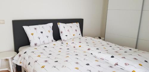 un letto con un piumone bianco e due cuscini di Elite 1 a Koksijde