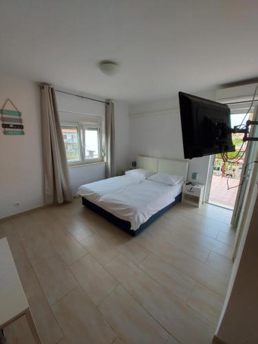 a bedroom with a bed and a flat screen tv at Guest House Nina in Novigrad Istria