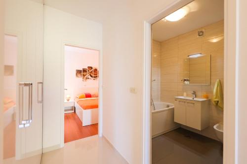 a bathroom with a tub and a sink and a bed at Villa Pino with Pool, Sauna & Jacuzzi in Petrcane