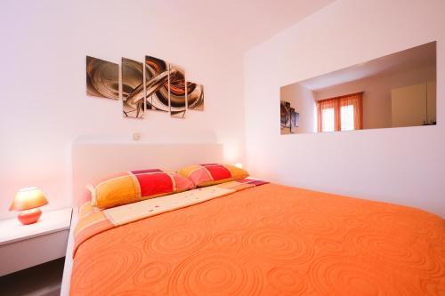a bedroom with a large orange bed with a mirror at Villa Pino with Pool, Sauna & Jacuzzi in Petrcane