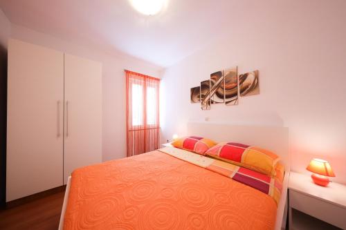 a bedroom with a large bed with colorful pillows at Villa Pino with Pool, Sauna & Jacuzzi in Petrcane