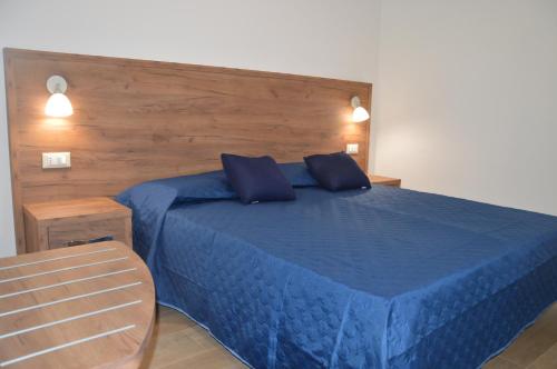 a bedroom with a blue bed with two blue pillows at I fiori del Pollino - Guest House in San Severino Lucano