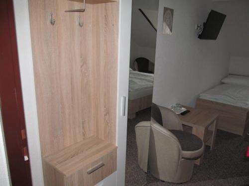 a room with a door with a chair and a bedroom at A+S Penzion Podzamok in Spišské Podhradie