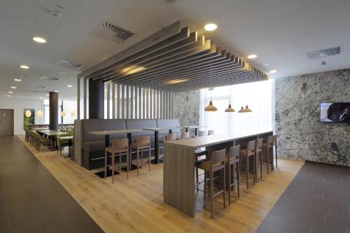 a restaurant with tables and chairs and a bar at Holiday Inn Express Friedrichshafen by IHG in Friedrichshafen