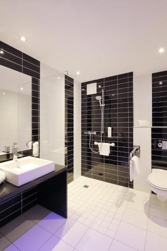 a bathroom with a sink and a toilet at Holiday Inn Express Friedrichshafen by IHG in Friedrichshafen
