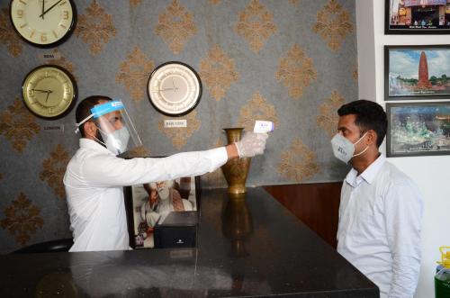 two men wearing masks playing a video game at Hotel 49 in Amritsar