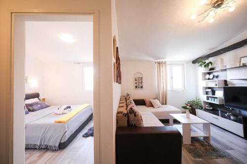 a living room with a bed and a couch at Apartment Rita in Zadar