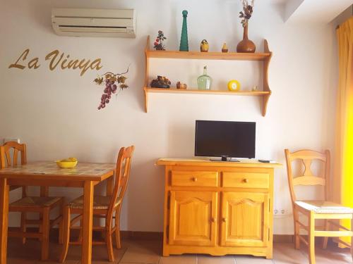 a dining room with a table and a tv on a wall at Can Panxeta in Pallaresos