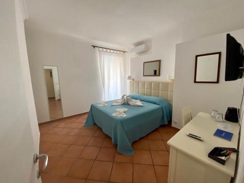 a bedroom with a blue bed in a room at Tropea Boutique Hotel in Tropea