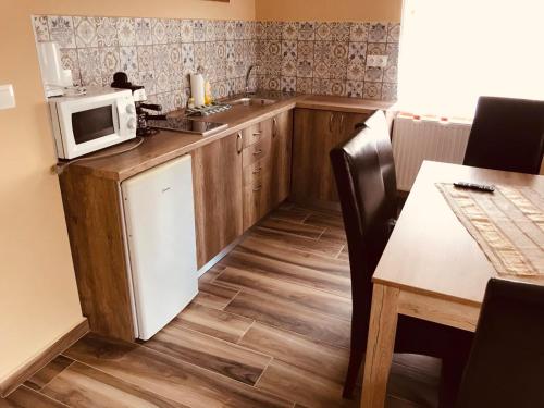 una pequeña cocina con microondas y mesa en Adrienn Apartman, en Sárvár