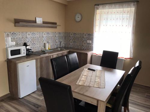a kitchen with a table and chairs and a microwave at Adrienn Apartman in Sárvár