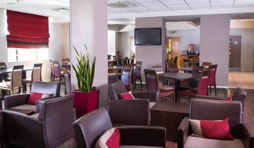 a dining room filled with tables and chairs at Holiday Inn Express London Chingford, an IHG Hotel in London