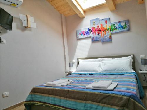 1 dormitorio con 1 cama con 2 toallas en FIORDAELISA APARTMENT, en Monforte dʼAlba