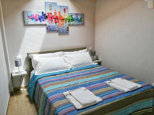 a bedroom with a bed with two towels on it at FIORDAELISA APARTMENT in Monforte dʼAlba