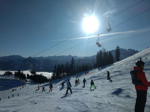 a group of people skiing down a snow covered ski slope at Wildente am See in Maishofen