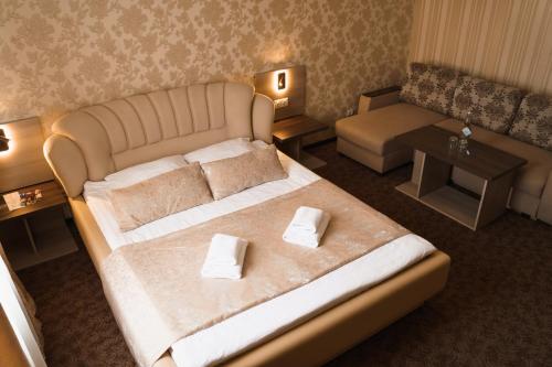 a bedroom with a large bed and a couch at Globus Hotel in Ternopilʼ