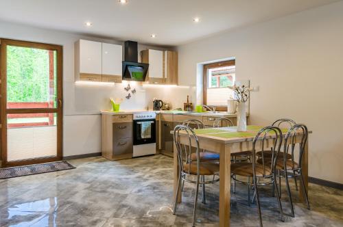 a kitchen with a table and chairs in a kitchen at Domki Pod Czarnym Groniem in Rzyki