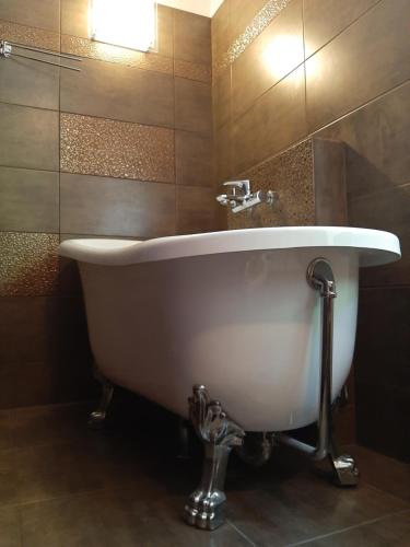 a bath tub in a bathroom with a sink at Champêtre Park View Apartments in Rīga