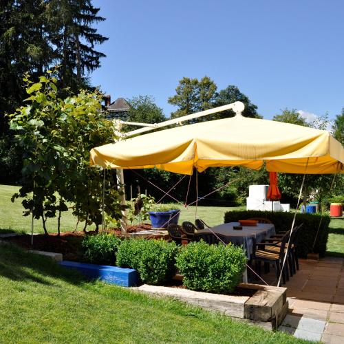 a large yellow umbrella over a table and chairs at Hotel Leitgebhof in Innsbruck