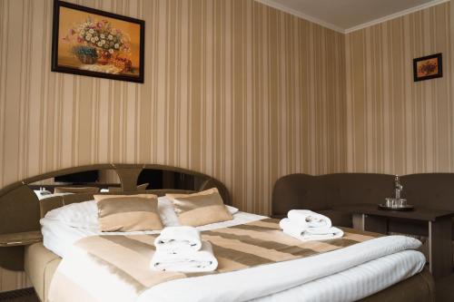 a bedroom with a large bed with towels on it at Globus Hotel in Ternopilʼ