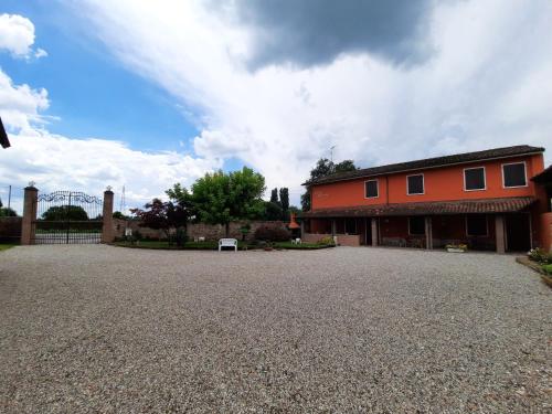 a large red building with a gravel driveway at CORTE MORONA in Marmirolo