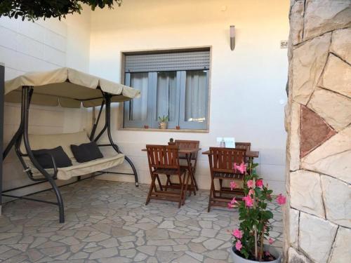 d'une terrasse avec un lit, des chaises et une table. dans l'établissement Camere a Oriente, à Torre dell'Orso