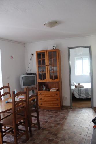 a living room with a television and a table and chairs at Casa Avô T1 in Avô
