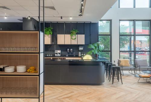 a kitchen with black cabinets and a dining room at Naalt Hotel Joinville in Joinville