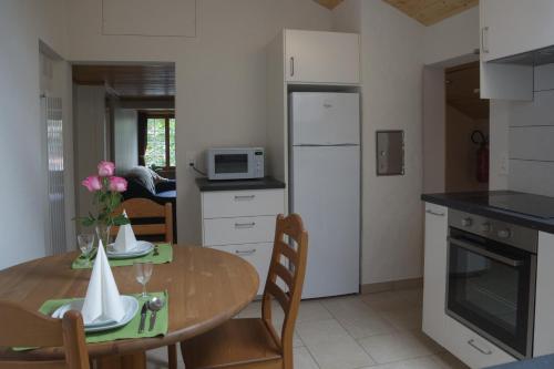 eine Küche mit einem Holztisch und eine Küche mit einem Kühlschrank in der Unterkunft OldSwissHome in Matten