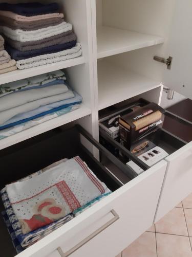 a white closet with a drawer filled with items at Ca' De' Mumi in Luino