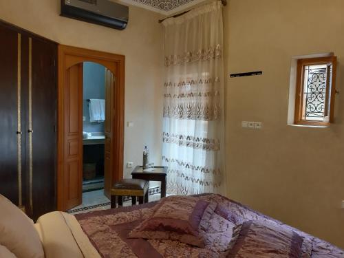 una camera da letto con un letto, una finestra e una scrivania di Riad Miral a Marrakech
