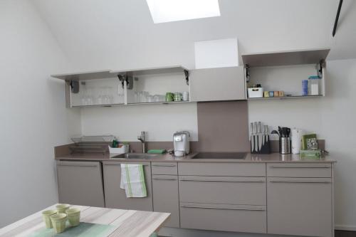 a kitchen with white cabinets and a wooden table at Casa Tua in Magliaso