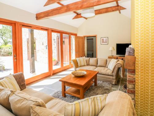 a living room with couches and a table at Fair Lea Barn in Lincoln