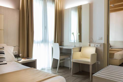 a hotel room with a desk and a chair at Hotel Alexander in Mestre