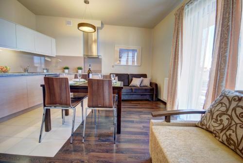 a kitchen and living room with a table and chairs at HelApart - Foka in Hel
