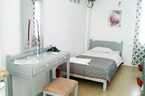 a bedroom with a desk and a bed with a mirror at Kalymnos Village in Masouri