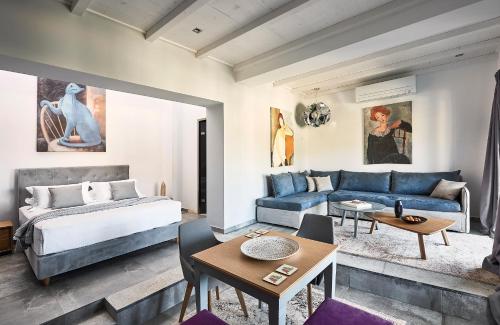 um quarto com uma cama e um sofá azul em EmGard Suites Kythnos em Kythnos