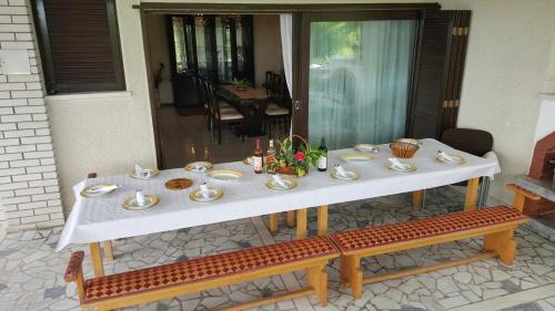 a white table with plates and cups on it at VILA PEKEČ in Mala Moštanica