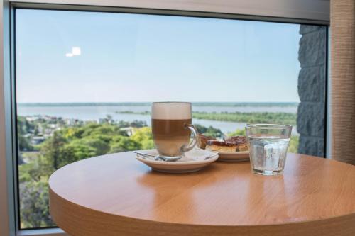 a table with a cup of coffee and a glass of water at Maran Suites & Towers in Paraná