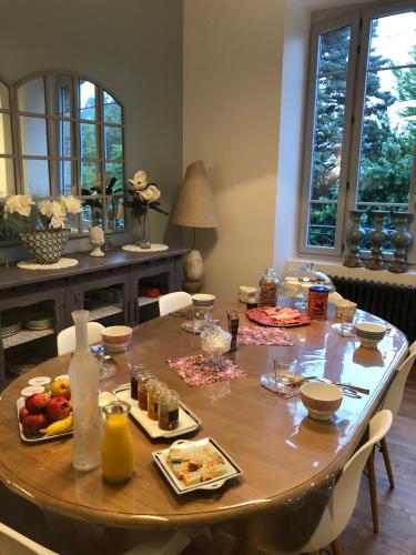 a wooden table with food on it in a living room at La Demeure in Sillé-le-Guillaume