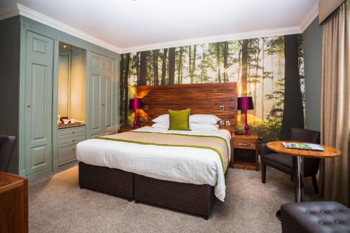 a bedroom with a bed and a desk and a table at The Moat House in Stafford